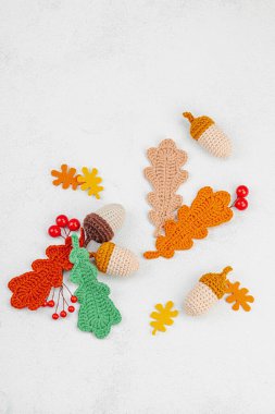 Geleneksel sonbahar süslemeleri. Farklı meşe palamudu ve yapraklar örülmüş, el yapımı, samimi bir hobi. Işık taşı arkaplan üzerine sonbahar dekorları, üst görünüm