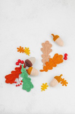 Geleneksel sonbahar süslemeleri. Farklı meşe palamudu ve yapraklar örülmüş, el yapımı, samimi bir hobi. Işık taşı arkaplan üzerine sonbahar dekorları, üst görünüm