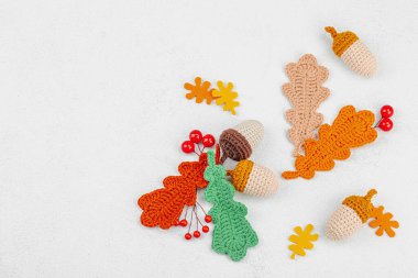 Geleneksel sonbahar süslemeleri. Farklı meşe palamudu ve yapraklar örülmüş, el yapımı, samimi bir hobi. Işık taşı arkaplan üzerine sonbahar dekorları, üst görünüm