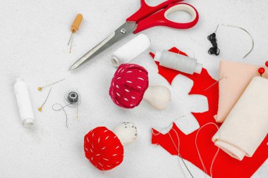 Cadılar Bayramı zanaatı. Yumuşak dikişli sineklik mantarlar, yaratıcı süreç, profesyonel aletler ve malzemeler. Hafif arkaplan, kapat