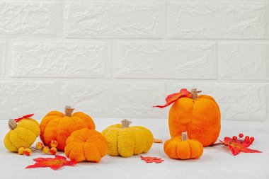 Cadılar Bayramı zanaatı. Yumuşak dikişli balkabakları, yaratıcılık süreci, sonbahar dekorasyonu, sonbahar yaprakları. Işık arkaplanı, kopyalama alanı