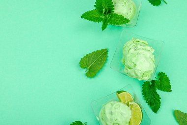 Modaya uygun limonlu dondurma. Çikolata damlaları, taze yapraklar, olgun limonlar. Yaz tatlısı, vejetaryen laktozsuz yemek. Pastel renk arkaplanı, üst görünüm