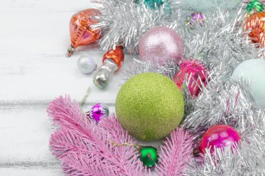 Moda Kitschmas geçmişi. Eski yılbaşı baloları, pembe köknar dalları, gümüş çelenkler. Şenlikli dekor, düz döşeme, beyaz ahşap tahtalar, yakın çekim.