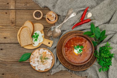 Geleneksel Ukrayna çorbası. Sıcak yemek, ulusal kırmızı çorba, klasik tarzda servis edilir. Sağlıklı yiyecekler, çavdar ekmeği, salo ve soğan yemeye hazır. Tahta kaplama arka plan, üst görünüm