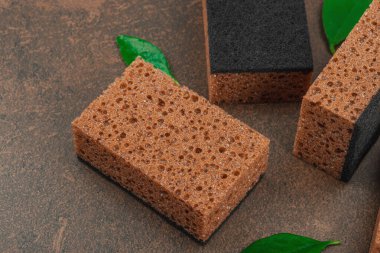 Bulaşık yıkamak için bir çift sünger. Organik temizlik konsepti, kahve kokusu. Sıfır atık stili, sıcak kahverengi taş arka plan, düz yatış, yakın çekim