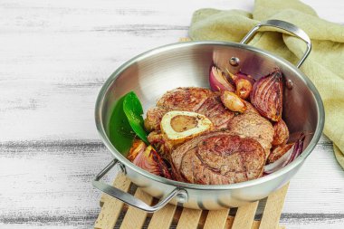 Ossobuco beef meat with spices and fresh herbs. Veal shank steak, traditional Italian ingredient for cooking healthy food. White wooden background, close up clipart