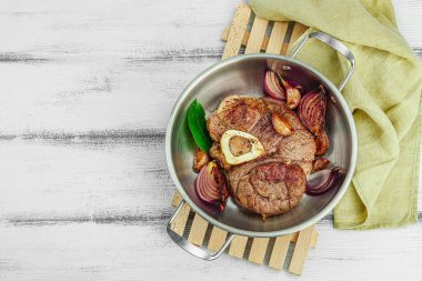 Ossobuco beef meat with spices and fresh herbs. Veal shank steak, traditional Italian ingredient for cooking healthy food. White wooden background, top view clipart