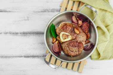 Ossobuco beef meat with spices and fresh herbs. Veal shank steak, traditional Italian ingredient for cooking healthy food. White wooden background, top view clipart