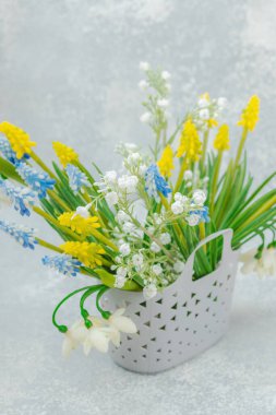 Bahar indirimi. Geleneksel çiçeklerle dolu bir alışveriş çantası. Tebrik kartı, sürpriz ya da hediye konsepti. Pastel tasarımı, hafif arkaplan, metin için yer