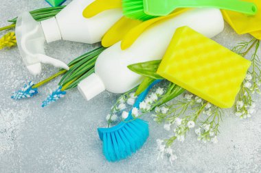 Bahar temizliği konsepti. Temizlik malzemeleri, şişeler, aletler ve aletler. Geleneksel bahar çiçekleri, açık arkaplan, kapat