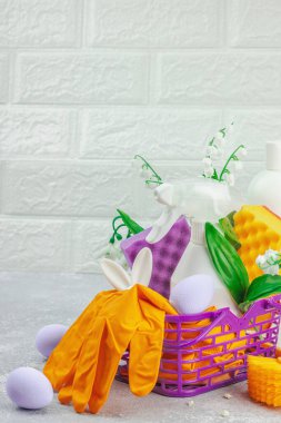 Paskalya temizliği konsepti. Temizlik malzemeleri, şişeler, aletler ve aletler. Geleneksel bahar çiçekleri, ışık arkaplanı, kopyalama alanı