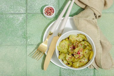 Bir kasede mayalanmış salatalık. Sağlıklı mide gıdaları, doğal probiyotik yiyecekler, organik turşular sebzeler. Yeşil karo arkaplan, üst görünüm