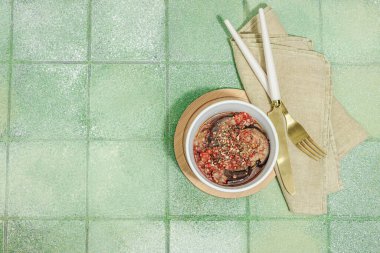 Bir kasede mayalanmış patlıcan. Sağlıklı mide gıdaları, doğal probiyotik yiyecekler, organik turşular sebzeler. Yeşil karo arkaplan, üst görünüm