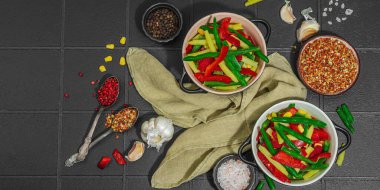 Canlı donmuş sebze karışımı, sarı ve yeşil fasulye, kırmızı dolmalık biber, mısır. Soğuk dokular, çeşitli baharatlar, vejetaryen yaşam tarzı. Siyah karo arkaplan, düz yatış, pankart biçimi