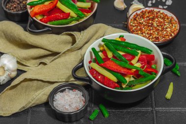 Canlı donmuş sebze karışımı, sarı ve yeşil fasulye, kırmızı dolmalık biber, mısır. Soğuk dokular, çeşitli baharatlar, vejetaryen yaşam tarzı. Siyah karo zemin, düz zemin, yakın plan