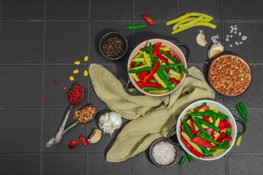 Canlı donmuş sebze karışımı, sarı ve yeşil fasulye, kırmızı dolmalık biber, mısır. Soğuk dokular, çeşitli baharatlar, vejetaryen yaşam tarzı. Siyah karo arkaplan, düz yatay, üst görünüm