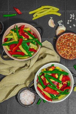 Canlı donmuş sebze karışımı, sarı ve yeşil fasulye, kırmızı dolmalık biber, mısır. Soğuk dokular, çeşitli baharatlar, vejetaryen yaşam tarzı. Siyah karo arkaplan, düz yatay, üst görünüm