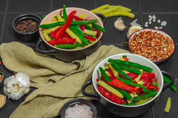 Canlı donmuş sebze karışımı, sarı ve yeşil fasulye, kırmızı dolmalık biber, mısır. Soğuk dokular, çeşitli baharatlar, vejetaryen yaşam tarzı. Siyah karo zemin, düz zemin, yakın plan