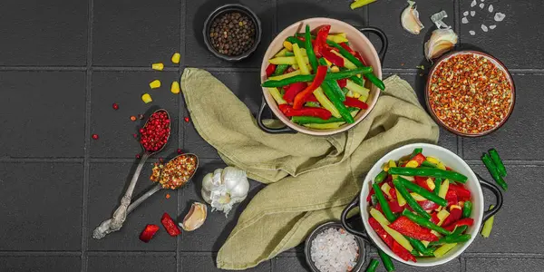 Canlı donmuş sebze karışımı, sarı ve yeşil fasulye, kırmızı dolmalık biber, mısır. Soğuk dokular, çeşitli baharatlar, vejetaryen yaşam tarzı. Siyah karo arkaplan, düz yatış, pankart biçimi