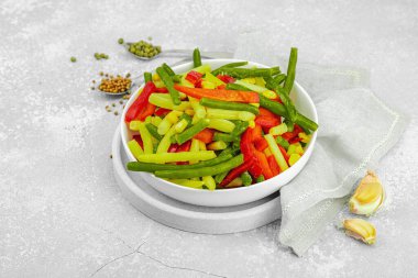 Canlı donmuş sebze karışımı, sarı ve yeşil fasulye, kırmızı dolmalık biber, mısır. Soğuk dokular, çeşitli baharatlar, vejetaryen yaşam tarzı. Hafif taş arkaplan, düz yatış, kopyalama alanı