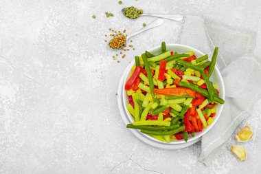 Canlı donmuş sebze karışımı, sarı ve yeşil fasulye, kırmızı dolmalık biber, mısır. Soğuk dokular, çeşitli baharatlar, vejetaryen yaşam tarzı. Hafif taş zemin, düz zemin, üst manzara