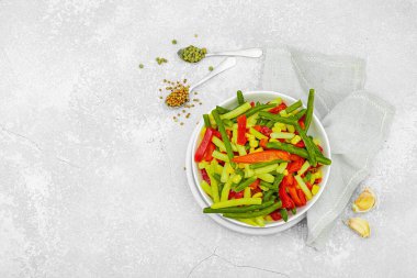 Canlı donmuş sebze karışımı, sarı ve yeşil fasulye, kırmızı dolmalık biber, mısır. Soğuk dokular, çeşitli baharatlar, vejetaryen yaşam tarzı. Hafif taş zemin, düz zemin, üst manzara