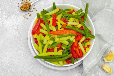 Canlı donmuş sebze karışımı, sarı ve yeşil fasulye, kırmızı dolmalık biber, mısır. Soğuk dokular, çeşitli baharatlar, vejetaryen yaşam tarzı. Hafif taş zemin, düz zemin, üst manzara
