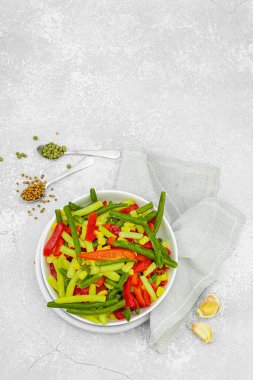 Canlı donmuş sebze karışımı, sarı ve yeşil fasulye, kırmızı dolmalık biber, mısır. Soğuk dokular, çeşitli baharatlar, vejetaryen yaşam tarzı. Hafif taş zemin, düz zemin, üst manzara