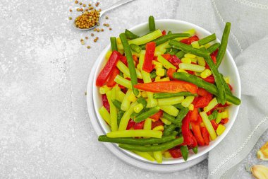 Canlı donmuş sebze karışımı, sarı ve yeşil fasulye, kırmızı dolmalık biber, mısır. Soğuk dokular, çeşitli baharatlar, vejetaryen yaşam tarzı. Hafif taş zemin, düz zemin, üst manzara