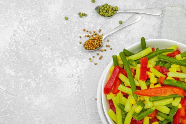 Canlı donmuş sebze karışımı, sarı ve yeşil fasulye, kırmızı dolmalık biber, mısır. Soğuk dokular, çeşitli baharatlar, vejetaryen yaşam tarzı. Hafif taş zemin, düz zemin, üst manzara