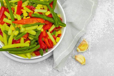 Canlı donmuş sebze karışımı, sarı ve yeşil fasulye, kırmızı dolmalık biber, mısır. Soğuk dokular, çeşitli baharatlar, vejetaryen yaşam tarzı. Hafif taş zemin, düz zemin, üst manzara