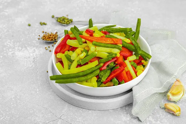 Canlı donmuş sebze karışımı, sarı ve yeşil fasulye, kırmızı dolmalık biber, mısır. Soğuk dokular, çeşitli baharatlar, vejetaryen yaşam tarzı. Hafif taş arkaplan, düz yatış, kopyalama alanı