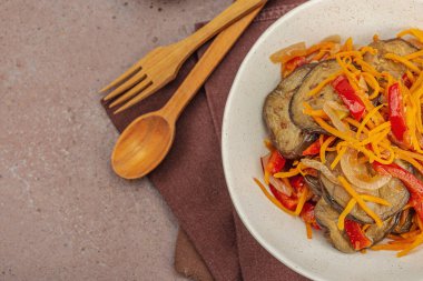 Son moda bir kasede canlı salata. Mayalanmış patlıcan, dolmalık biber, havuç ve soğan. Sağlıklı mide gıdaları, doğal probiyotik yiyecekler, organik turşular sebzeler. Sıcak kahverengi arkaplan, üst görünüm