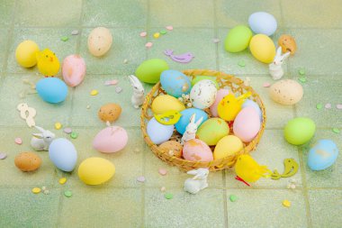 Canlı Paskalya konsepti. Geleneksel bayram sembolleri. Yumurtalar, tavşanlar ve kuşlar. Yaratıcı düz döşeme, yeşil fayans arkaplan, kopyalama alanı