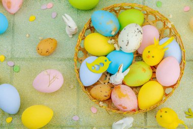 Canlı Paskalya konsepti. Geleneksel bayram sembolleri. Yumurtalar, tavşanlar ve kuşlar. Yaratıcı düz döşeme, yeşil fayans arkaplan, üst görünüm