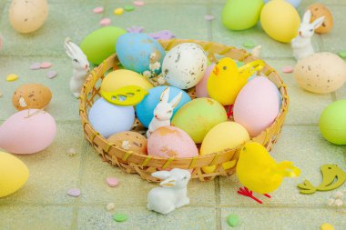 Canlı Paskalya konsepti. Geleneksel bayram sembolleri. Yumurtalar, tavşanlar ve kuşlar. Yaratıcı düz döşeme, yeşil fayans arkaplan, kapat