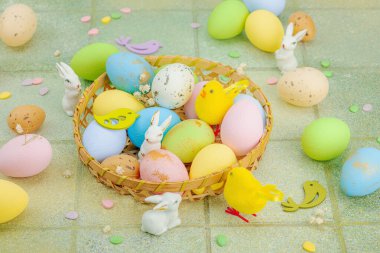 Canlı Paskalya konsepti. Geleneksel bayram sembolleri. Yumurtalar, tavşanlar ve kuşlar. Yaratıcı düz döşeme, yeşil fayans arkaplan, kapat