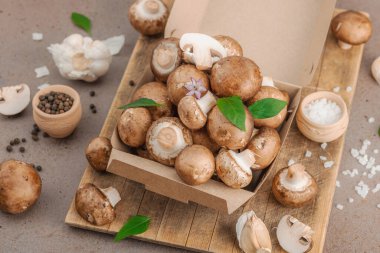 Baharatlı ve otlu taze taze taze kremini mantarlar. Vejetaryen yemeği pişirmek için sağlıklı malzeme. Çiftlikten masaya konsept, düz yatak, sıcak kahverengi arka plan, yakın çekim