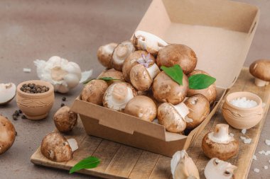 Baharatlı ve otlu taze taze taze kremini mantarlar. Vejetaryen yemeği pişirmek için sağlıklı malzeme. Çiftlikten masaya konsept, düz yatak, sıcak kahverengi arka plan, yakın çekim