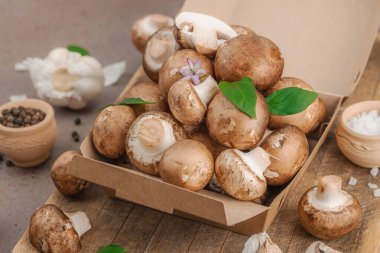 Baharatlı ve otlu taze taze taze kremini mantarlar. Vejetaryen yemeği pişirmek için sağlıklı malzeme. Çiftlikten masaya konsept, düz yatak, sıcak kahverengi arka plan, yakın çekim