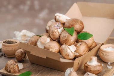 Baharatlı ve otlu taze taze taze kremini mantarlar. Vejetaryen yemeği pişirmek için sağlıklı malzeme. Çiftlikten masaya konsept, düz yatak, sıcak kahverengi arka plan, yakın çekim