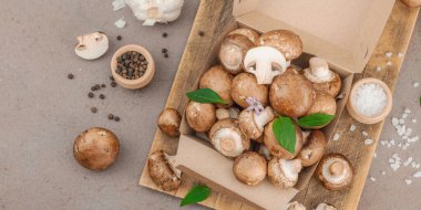 Baharatlı ve otlu taze taze taze kremini mantarlar. Vejetaryen yemeği pişirmek için sağlıklı malzeme. Çiftlikten masaya konsept, düz konum, sıcak kahverengi arkaplan, afiş biçimi