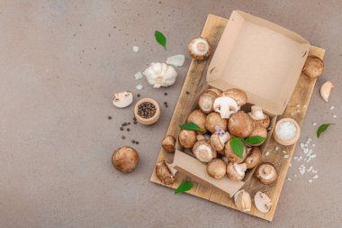 Baharatlı ve otlu taze taze taze kremini mantarlar. Vejetaryen yemeği pişirmek için sağlıklı malzeme. Çiftlikten masaya konsept, düz yatak, sıcak kahverengi arka plan, üst görünüm