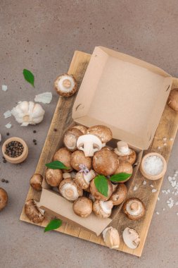 Baharatlı ve otlu taze taze taze kremini mantarlar. Vejetaryen yemeği pişirmek için sağlıklı malzeme. Çiftlikten masaya konsept, düz yatak, sıcak kahverengi arka plan, üst görünüm