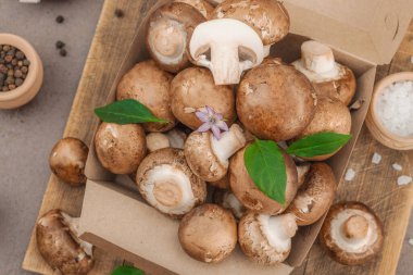 Baharatlı ve otlu taze taze taze kremini mantarlar. Vejetaryen yemeği pişirmek için sağlıklı malzeme. Çiftlikten masaya konsept, düz yatak, sıcak kahverengi arka plan, üst görünüm