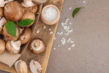 Baharatlı ve otlu taze taze taze kremini mantarlar. Vejetaryen yemeği pişirmek için sağlıklı malzeme. Çiftlikten masaya konsept, düz yatak, sıcak kahverengi arka plan, üst görünüm