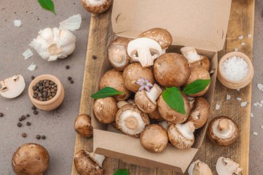 Baharatlı ve otlu taze taze taze kremini mantarlar. Vejetaryen yemeği pişirmek için sağlıklı malzeme. Çiftlikten masaya konsept, düz yatak, sıcak kahverengi arka plan, üst görünüm