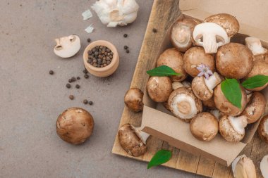 Baharatlı ve otlu taze taze taze kremini mantarlar. Vejetaryen yemeği pişirmek için sağlıklı malzeme. Çiftlikten masaya konsept, düz yatak, sıcak kahverengi arka plan, üst görünüm