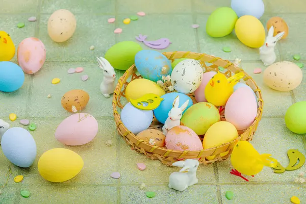 Canlı Paskalya konsepti. Geleneksel bayram sembolleri. Yumurtalar, tavşanlar ve kuşlar. Yaratıcı düz döşeme, yeşil fayans arkaplan, kapat