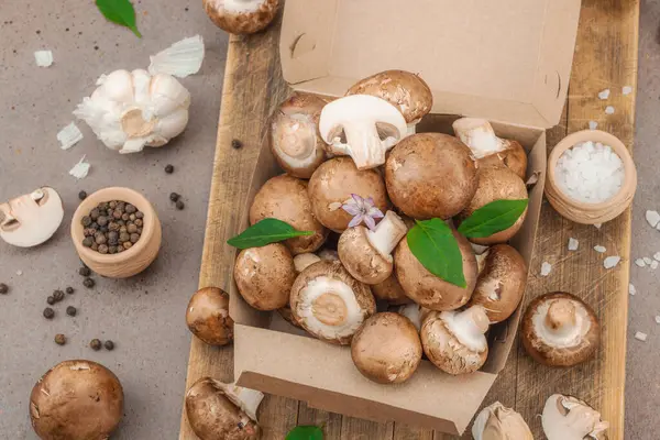 Baharatlı ve otlu taze taze taze kremini mantarlar. Vejetaryen yemeği pişirmek için sağlıklı malzeme. Çiftlikten masaya konsept, düz yatak, sıcak kahverengi arka plan, üst görünüm